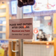 restaurant sign asking patrons to wait outside for pickup